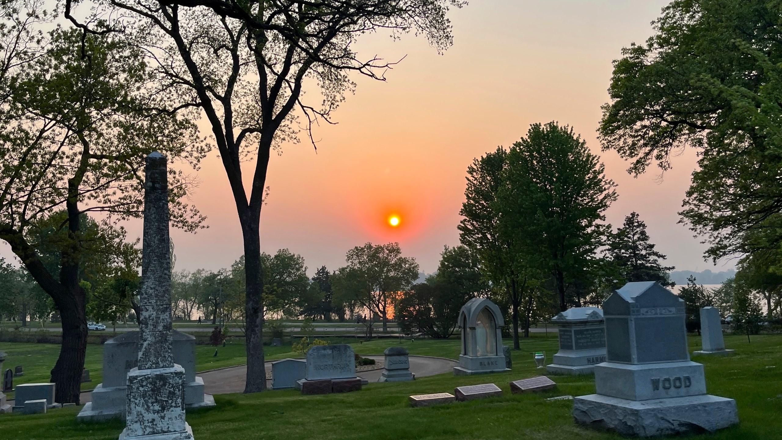 The sunset is seen through a layer of wildfire smoke over Lakewood Cemetery in Minneapolis on Sunday, May 12, 2024. (Ben Hovland/Minnesota Public Radio via AP)