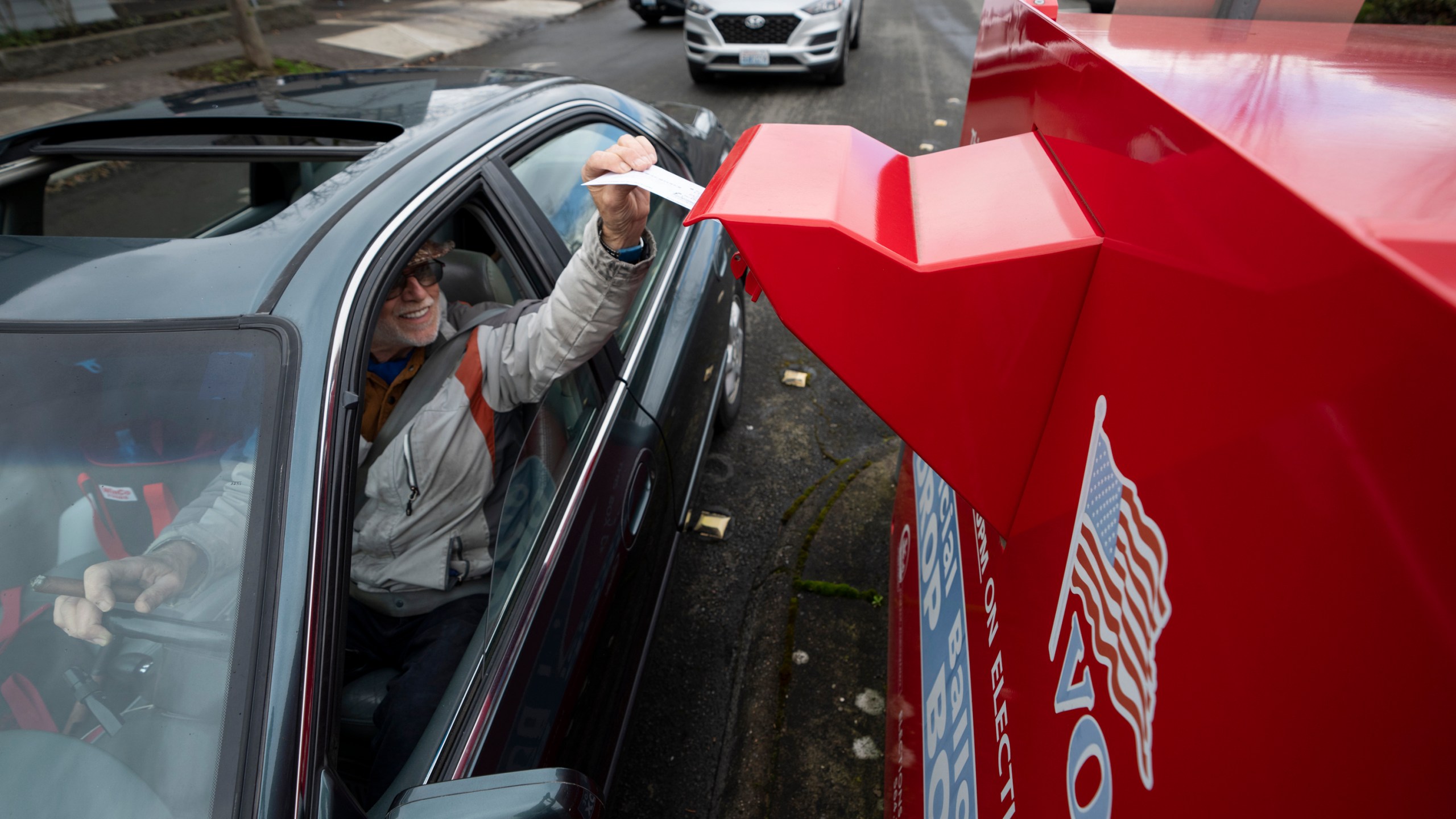 FILE - A voter drops off a vote-by-mail ballot on March 12, 2024, during the presidential primary election in Vancouver, Wash. At rallies and in social media posts, former President Donald Trump has been trying to assure Republican voters that casting ballots by mail and other forms of early voting are “all good options.” (AP Photo/Jenny Kane, File)