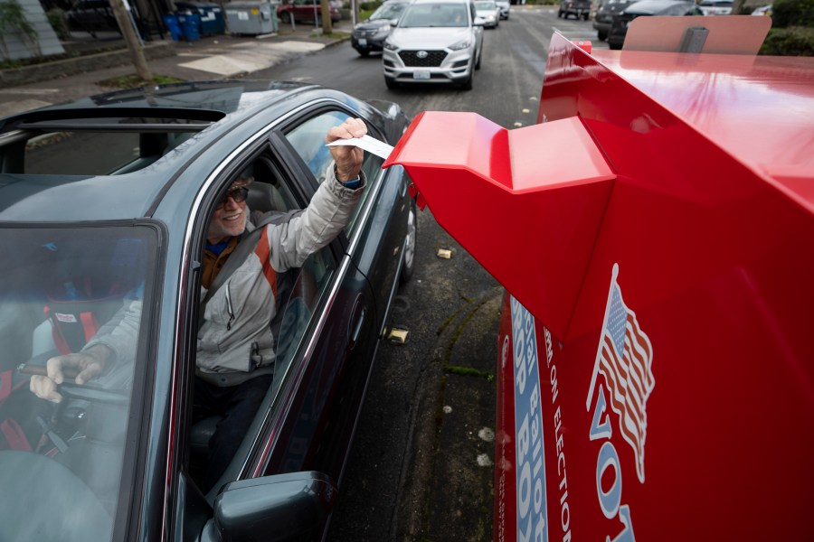 FILE - A voter drops off a vote-by-mail ballot on March 12, 2024, during the presidential primary election in Vancouver, Wash. At rallies and in social media posts, former President Donald Trump has been trying to assure Republican voters that casting ballots by mail and other forms of early voting are “all good options.” (AP Photo/Jenny Kane, File)