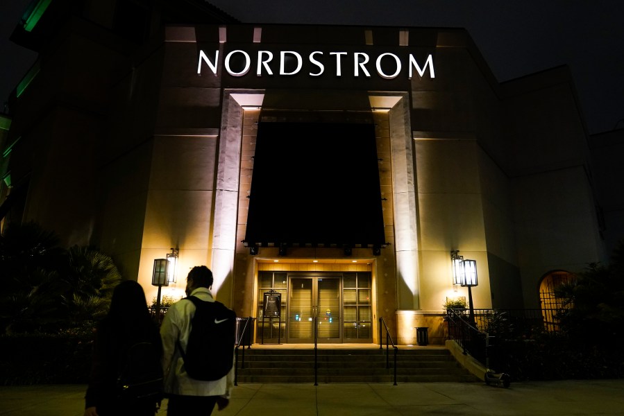 FILE - Two pedestrians walk near an entrance to a Nordstrom department store at the Grove mall in Los Angeles, Dec. 2, 2021. Bruce Nordstrom, a retail executive who helped expand his family’s Pacific Northwest department store chain into an upscale national brand, has died. Seattle-based Nordstrom Inc. said its former chairman died at his home, Saturday, May 18, 2024. He was 90. (AP Photo/Jae C. Hong, File)