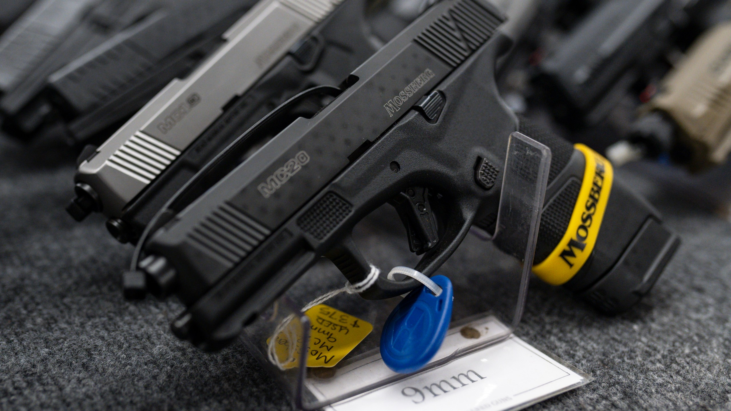 FILE - Pistols sit on display during the first day of the Silver Spur Gun and Blade Show, Jan. 22, 2022, in Odessa, Texas. On Monday, May 20, 2024, a federal judge blocked the Biden administration from enforcing a new rule in Texas that would require firearms dealers to run background checks on buyers at gun shows or other places outside brick-and-mortar stores. (Eli Hartman/Odessa American via AP, File)