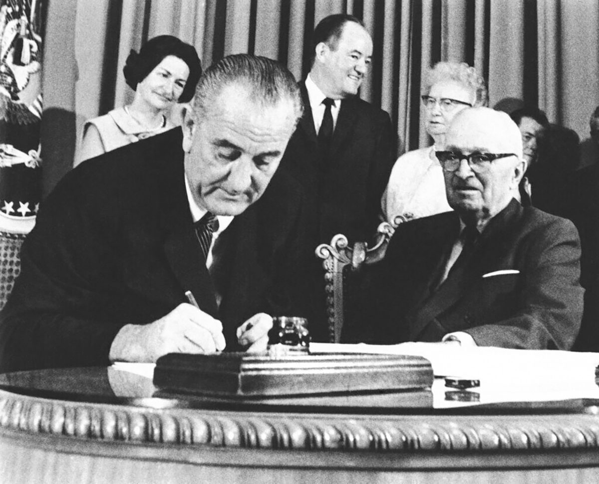 FILE - President Lyndon B. Johnson signs the Medicare bill in Independence, Mo., July 30, 1965. At right is former President Harry Truman. The Supreme Court's pending Idaho abortion ruling may hinge on how federal spending power might protect doctors against a state's criminal code. For guidance, the justices can look to the very beginning of Medicare in the 1960s, when the promise of federal funding finally persuaded hospitals in the Jim Crow South to desegregate. (AP Photo, File)