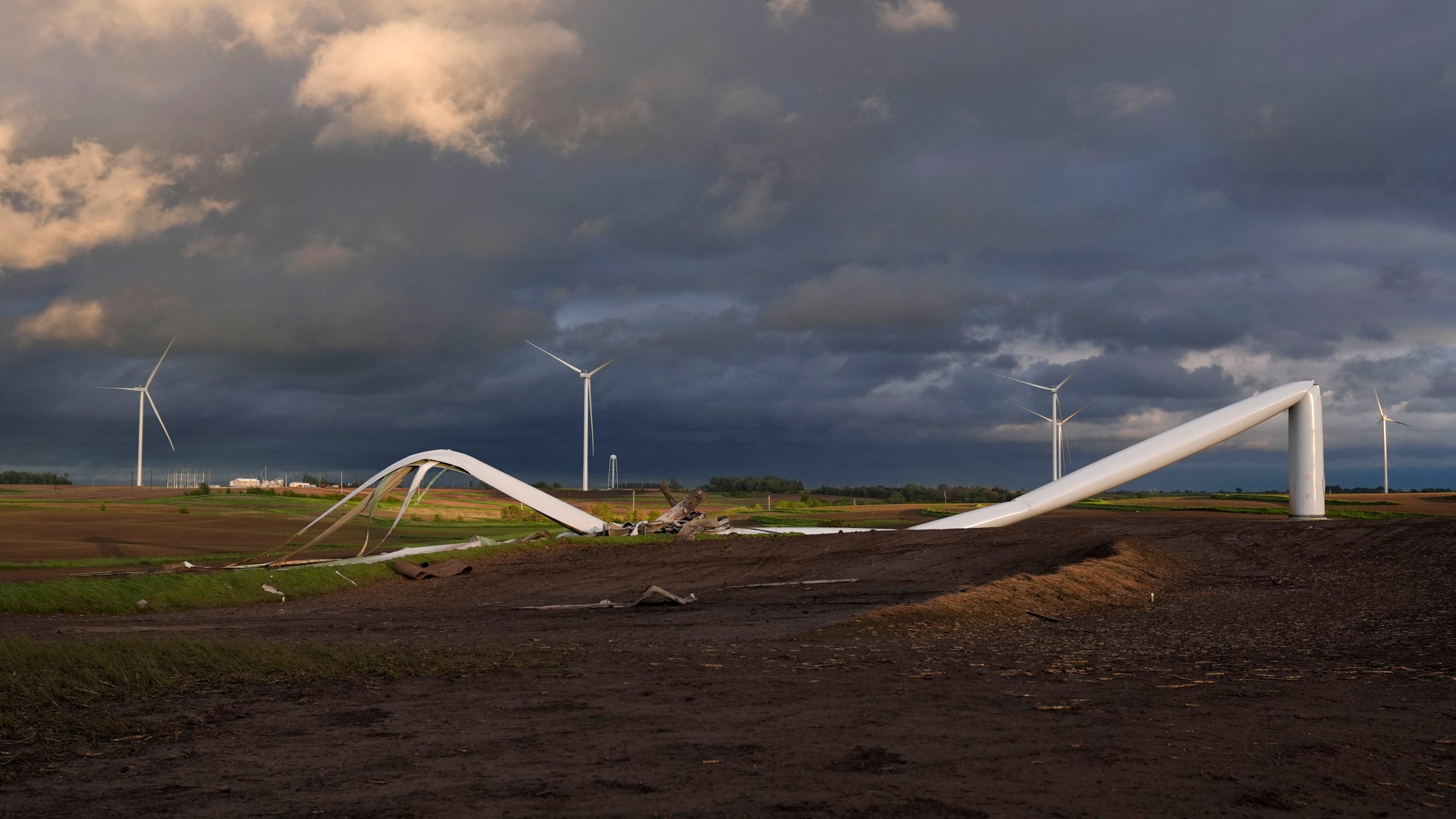 The remains of a tornado-damaged wind turbine touch the ground in a field, Tuesday, May 21, 2024, near Prescott, Iowa. (AP Photo/Charlie Neibergall)