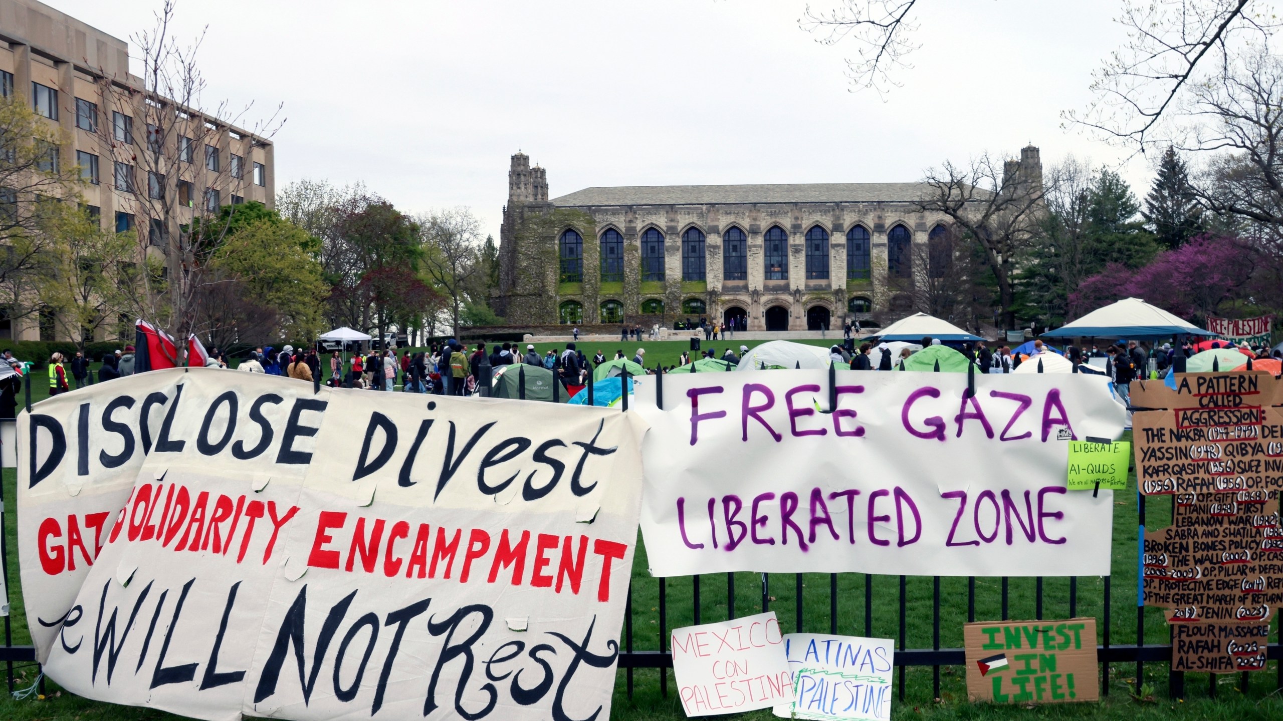 FILE - Signs are displayed outside a tent encampment at Northwestern University on Friday, April 26, 2024, in Evanston, Illinois. Leaders from Northwestern University, the University of California, Los Angeles, and Rutgers University are expected to testify before Congress on Thursday, the latest in a series of hearings spearheaded by House Republicans into how colleges have responded to pro-Palestinian protests on their campuses. (AP Photo/Teresa Crawford, file)