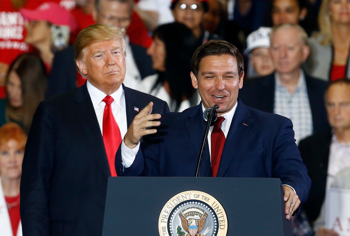 FILE- President Donald Trump stands behind gubernatorial candidate Ron DeSantis at a rally in Pensacola, Fla., Nov. 3, 2018. Trump and DeSantis are signaling to donors that they're putting their rivalry behind them. DeSantis has convened his allies this week in Fort Lauderdale, Fla., to press them to support Trump. He argued to them Wednesday, May 22, 2024, that they need to work together to prevent President Joe Biden from winning a second term. (AP Photo/Butch Dill, File)