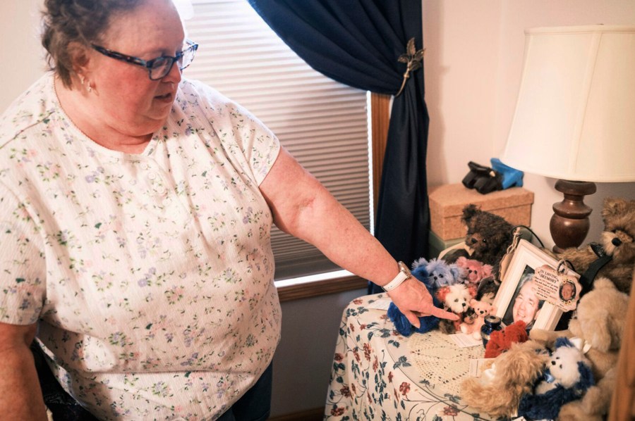 Nancy Gag Braun points to a small urn holding the ashes of her late husband Steve Braun, in her Mankato, Minn., bedroom on May 13, 2024. After caring for Steven at home became too much for her to handle, he was at the hospital while they waited on a long-term care placement. “I cried many nights,” Braun said. “I felt so guilty.” (Casey Ek/CNHI News via AP)