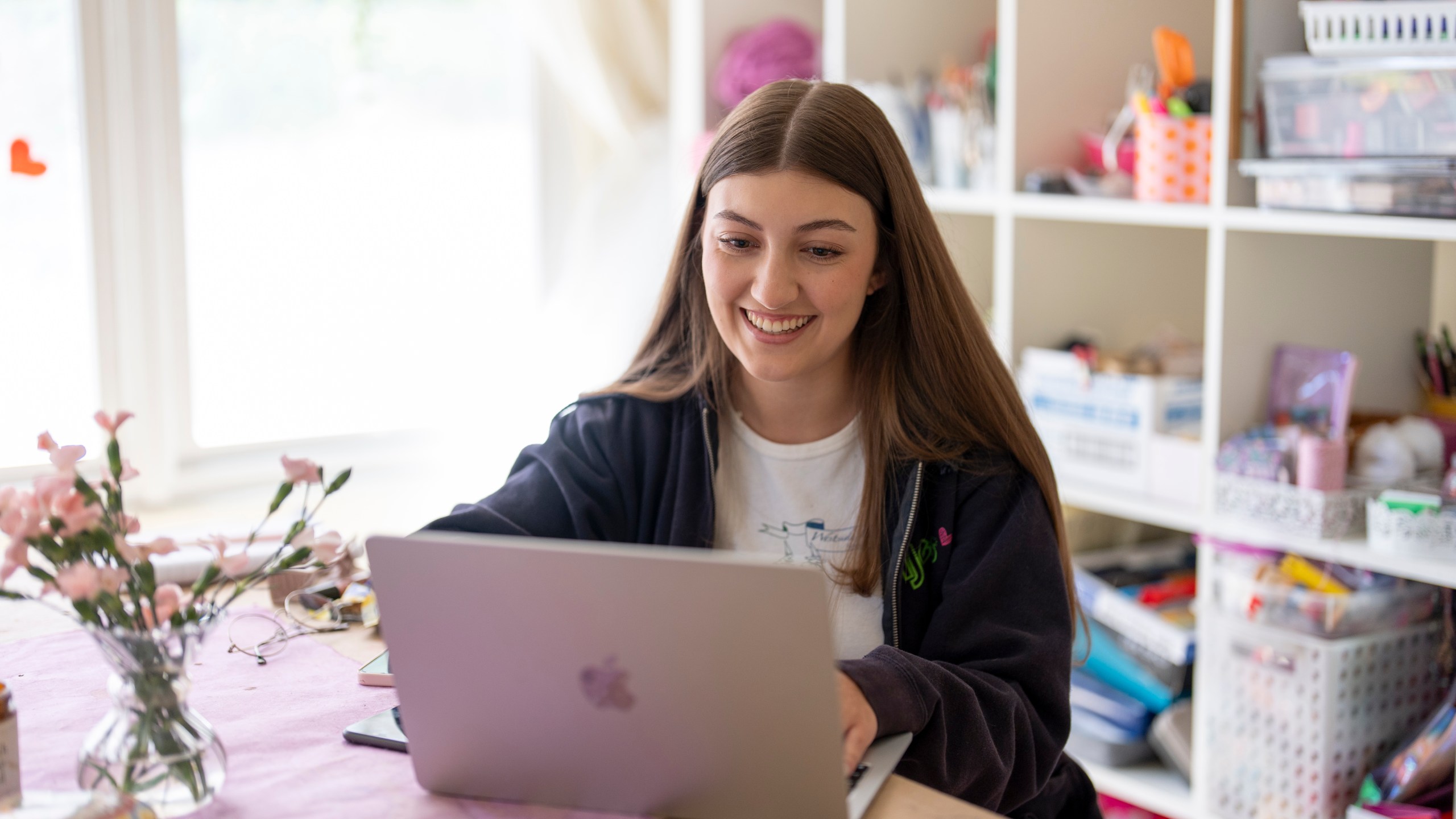 Amea Wadsworth works on her computer at her home, Friday, April 19, 2024, in San Diego. Wadsworth, who moved back home after graduating college, wanted to use her first full-time job as a chance to save, and a moment to take a hard look at her spending activity. (AP Photo/Gregory Bull)