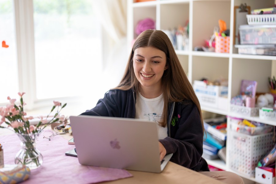 Amea Wadsworth works on her computer at her home, Friday, April 19, 2024, in San Diego. Wadsworth, who moved back home after graduating college, wanted to use her first full-time job as a chance to save, and a moment to take a hard look at her spending activity. (AP Photo/Gregory Bull)