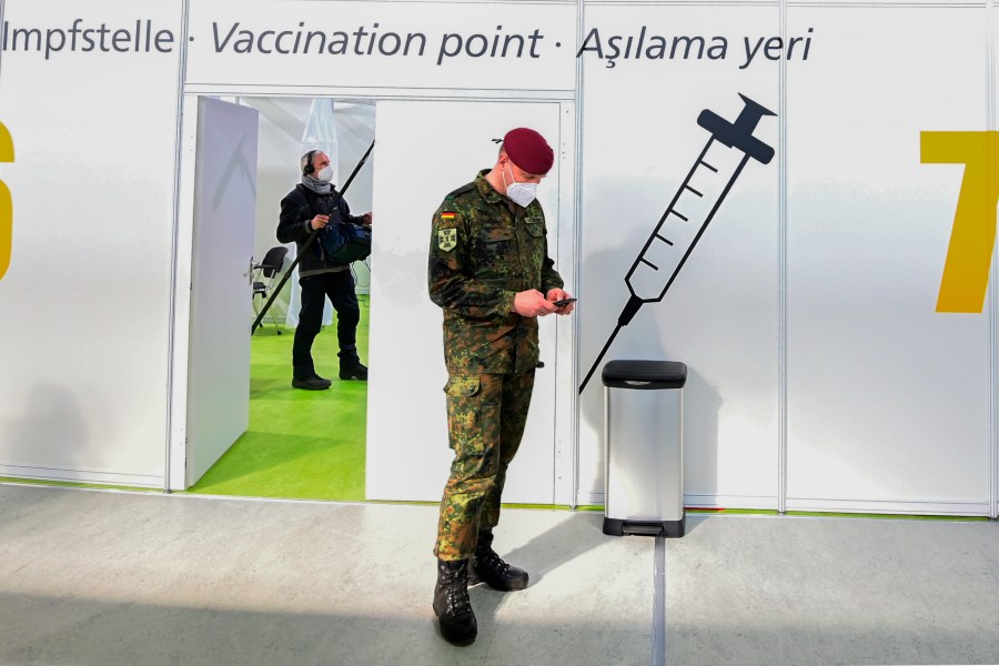 FILE - A soldier of the German Armed Forces Bundeswehr stands inside a new vaccination centre at the former Tempelhof airport in Berlin, Germany, before its opening on Monday, March 8, 2021. Germany has scrapped a requirement for its military servicepeople to be vaccinated against COVID-19. Members of the German military, the Bundeswehr, are required to get vaccinations against a number of diseases — including measles, mumps and flu. COVID-19 was added to the list in November 2021, meaning that anyone who refused to get vaccinated against it could face disciplinary measures. (Tobias Schwarz / Pool via AP, File)