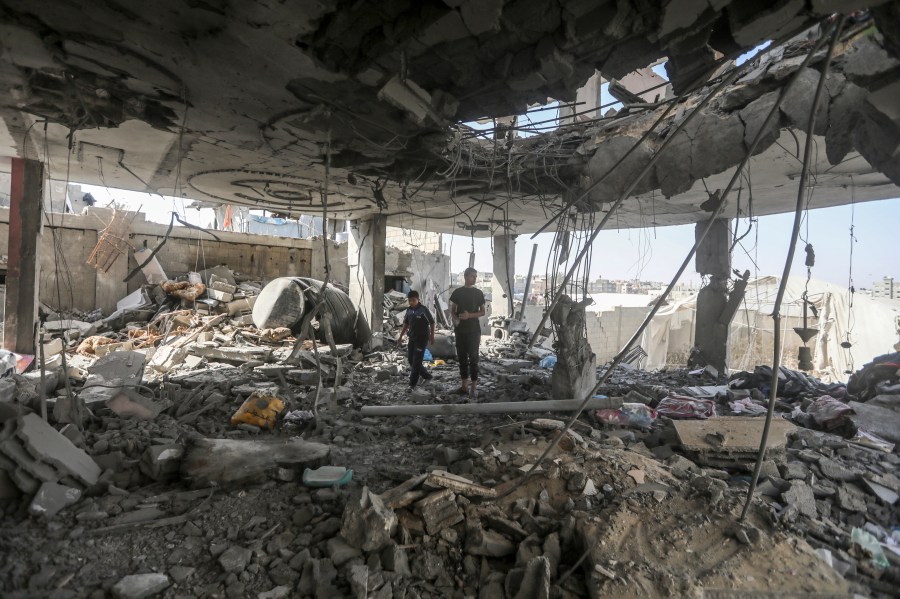 Palestinians stand in the ruins of a home destroyed by an Israeli strike in Rafah, southern Gaza Strip, that killed at least two adults and five children under 16 from the Chahine family on May 3, 2024.