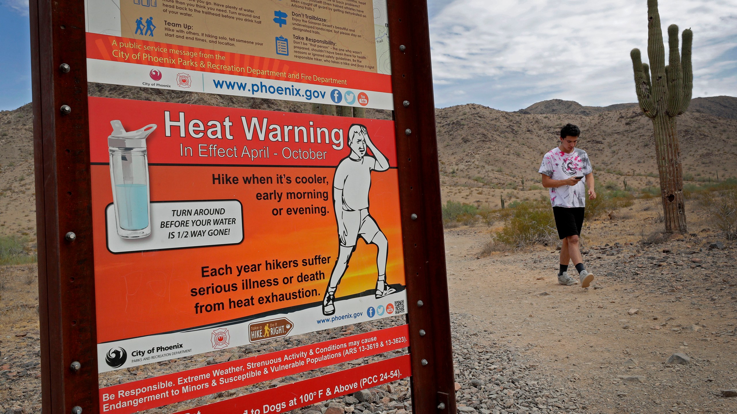 FILE - A hiker finishes his morning walk at the South Mountain Preserve to beat the high temperatures, July 11, 2019, in Phoenix. Parts of California, Nevada and Arizona are expected to bake this week as the first heat wave of the season arrives with triple-digit temperatures forecast for areas including Phoenix. Excessive heat warnings have been issued for most of the region from 10 a.m. Wednesday, June 5, 2024, to 8 p.m. Friday, June 7, due to the “dangerously hot conditions,” the National Weather Service in Phoenix said late Monday, June 3. (AP Photo/Matt York, File)