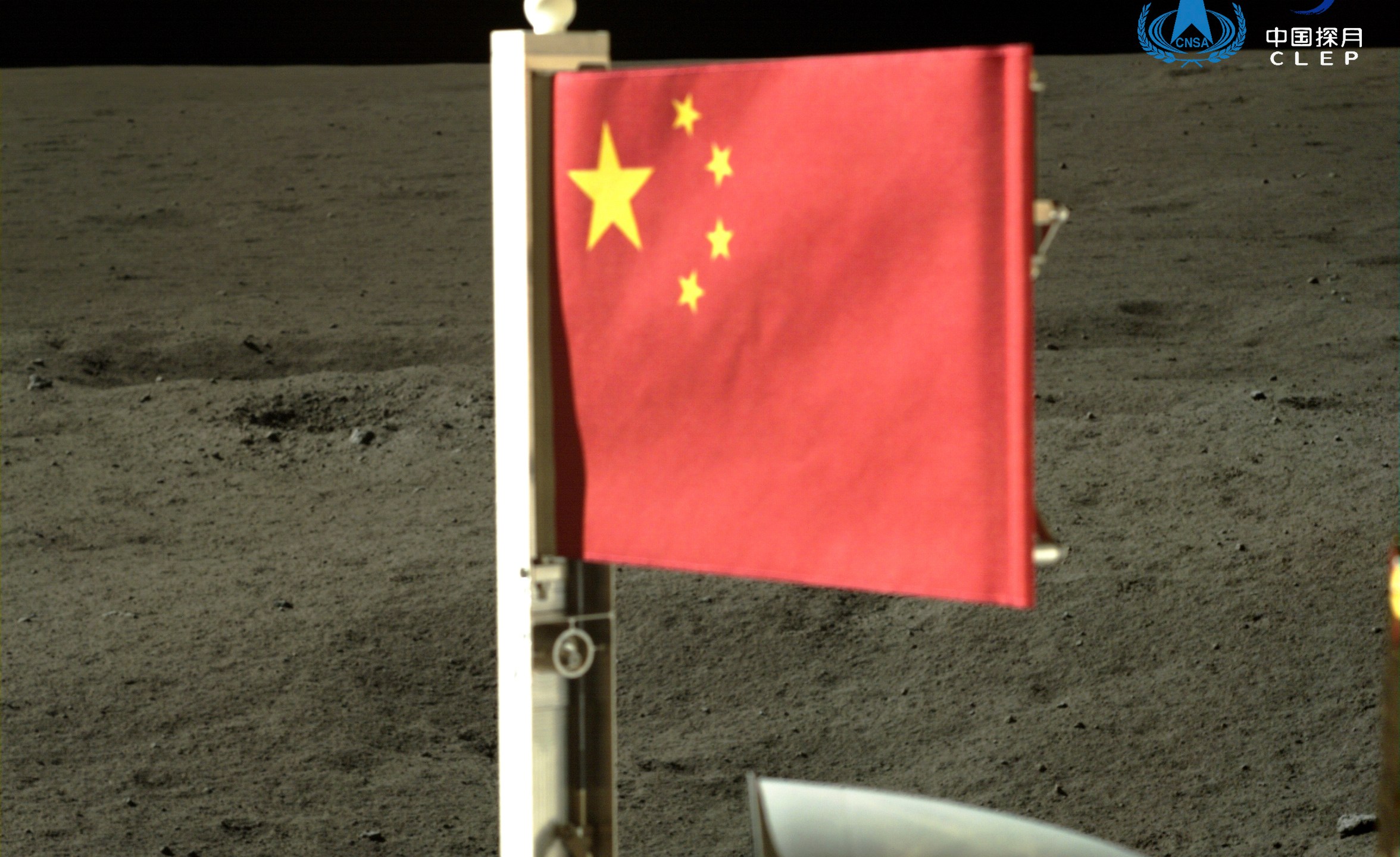 In this China National Space Administration (CNSA) handout image released by Xinhua News Agency, a Chinese national flag carried by the lander of Chang'e-6 probe unfurls at the moon's far side, Tuesday, June 4, 2024. China says a spacecraft carrying rock and soil samples from the far side of the moon has lifted off from the lunar surface to start its journey back to Earth. (CNSA/Xinhua via AP)