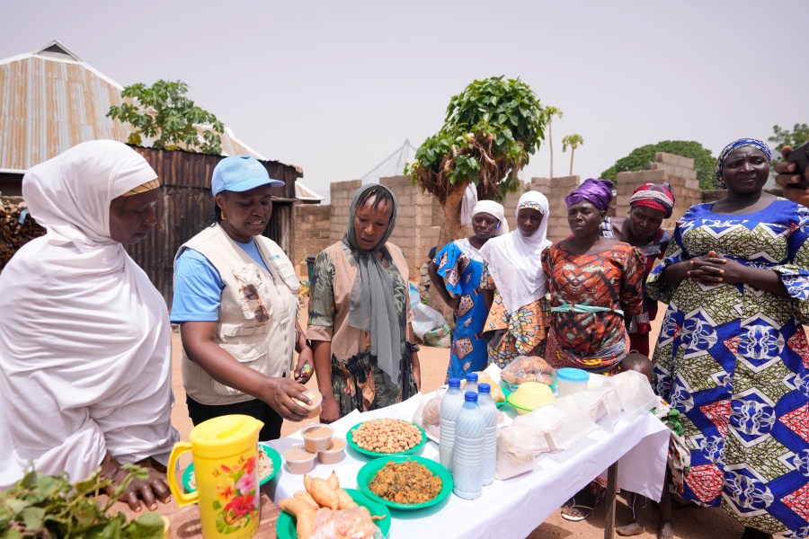 Philomena Irene, UNICEF Nutrition specialist, speaks to women about food that will boost their families' nutrient intake with tubers and grains like cassava, orange-fleshed sweet potato, in Kaltungo Poshereng Nigeria, Sunday, June 2, 2024. More than a dozen women gathered this week in Kaltungo's Poshereng village where they are learning at least 200 recipes they can prepare with those local foods which, in the absence of rain, are grown in sand-filled sacks that require small amounts of water. The training session mirrored the struggles of households who are more challenged amid Nigeria's worst cost of living crisis. (AP Photo/Sunday Alamba)