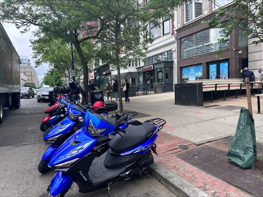 Delivery scooters are parked as drivers wait to pick up food for delivery, Thursday, June 6, 2024, in Boston. Boston and New York are cracking down on unlawful drivers, whom they say are ignoring traffic laws and making city streets more dangerous. (AP Photos/Michael Casey)