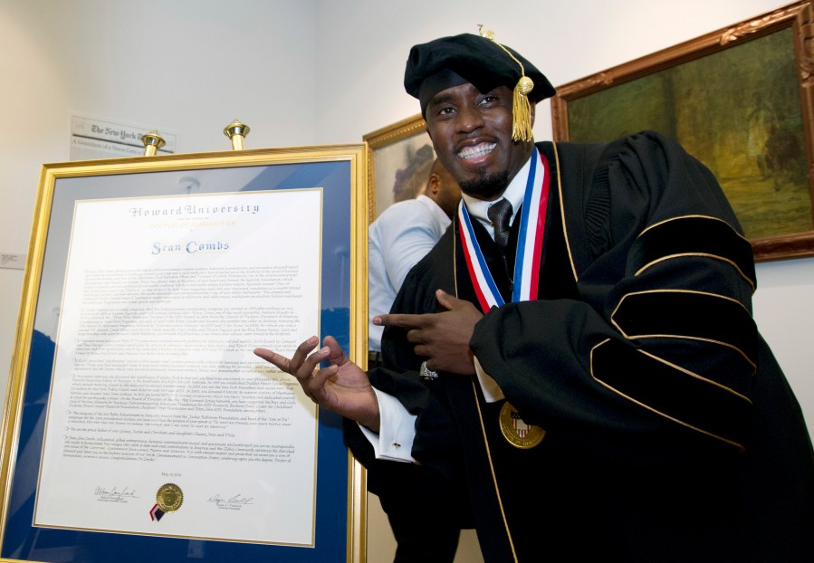 FILE - Entertainer and entrepreneur Sean Combs poses next to his honorary degree of Doctor of Humanities during the graduation ceremony at Howard University in Washington, Saturday, May 10, 2014. In a decision, Friday, June 7, 2024, Howard University is cutting ties to Combs, rescinding the honorary degree that was awarded to him and disbanding a scholarship program in his name. (AP Photo/Jose Luis Magana, File)