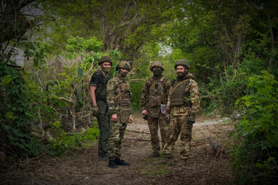 In this photo taken on Friday, April 26, 2024 and released by the Russian Defense Ministry Press Service, Russian soldiers look at a photographer near their position in an undisclosed location in Ukraine. (Russian Defense Ministry Press Service via AP)