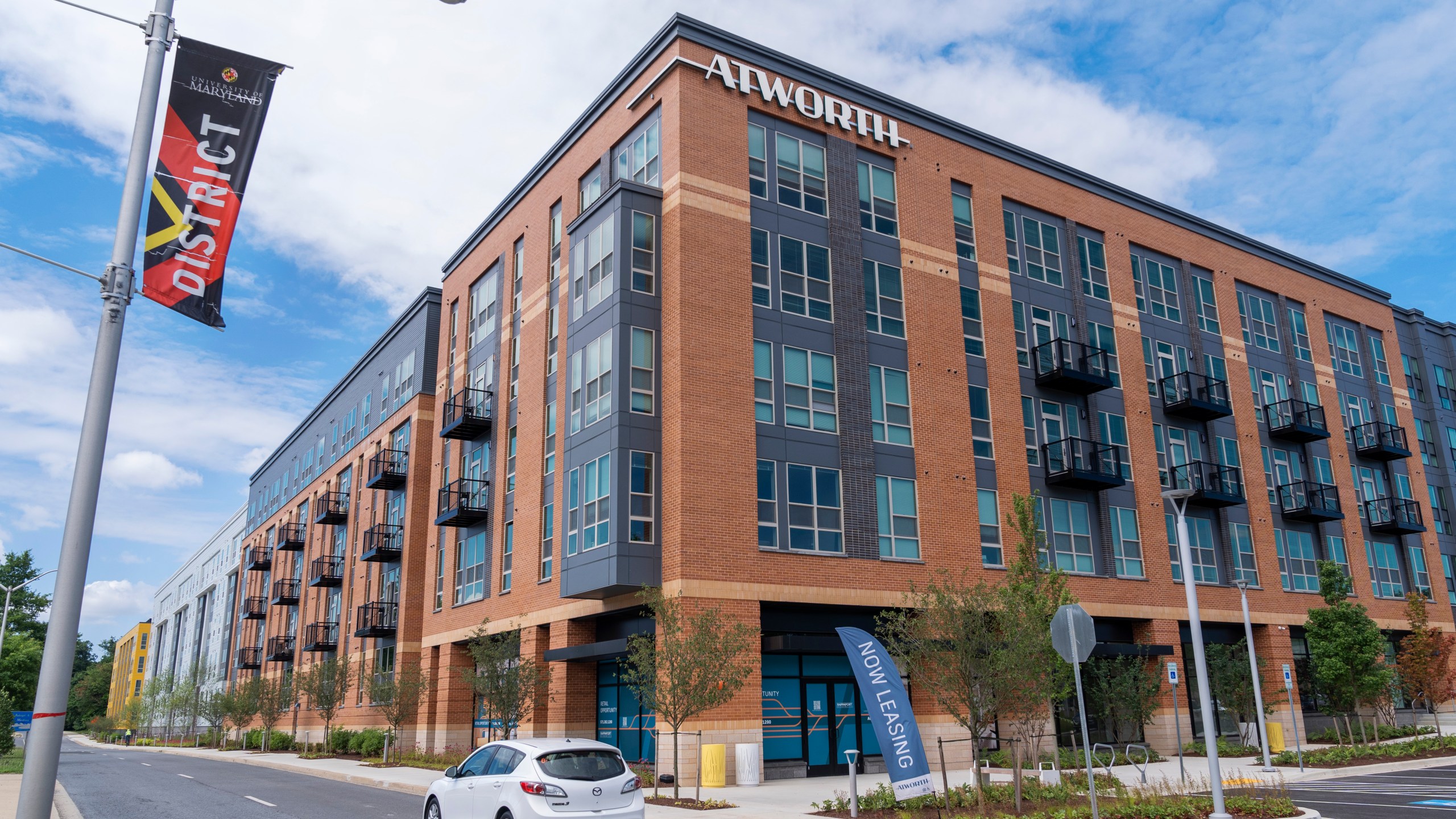 A car passes by the Atworth at College Park building in College Park, Md., Tuesday, June 11, 2024. The apartment building was built using investments from Amazon's Housing Equity Fund. The company said Tuesday its adding $1.4 billion to the fund in order to help preserve or construct more affordable housing units in three regions. (AP Photo/Jacquelyn Martin)