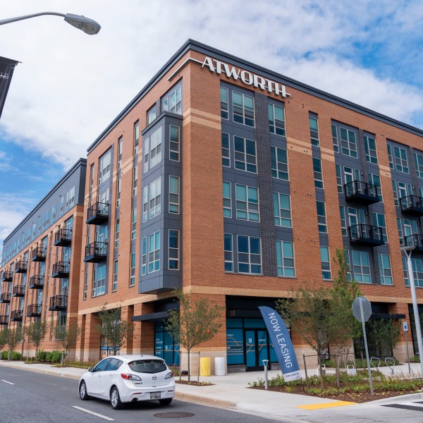 A car passes by the Atworth at College Park building in College Park, Md., Tuesday, June 11, 2024. The apartment building was built using investments from Amazon's Housing Equity Fund. The company said Tuesday its adding $1.4 billion to the fund in order to help preserve or construct more affordable housing units in three regions. (AP Photo/Jacquelyn Martin)