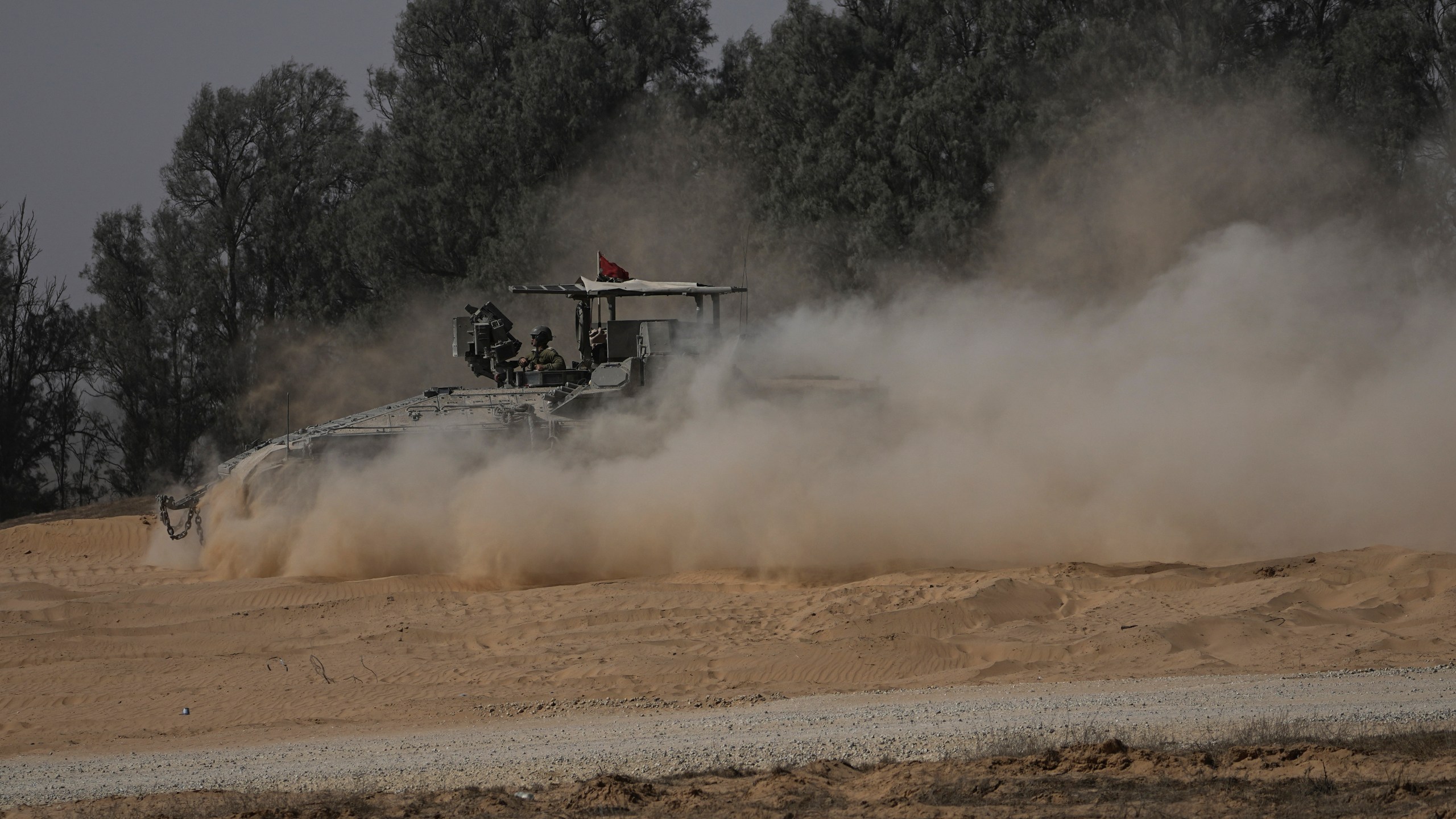 An Israeli military armored personnel carrier maneuvers near the Israel-Gaza border in southern Israel, Wednesday, June 12, 2024. (AP Photo/Tsafrir Abayov)