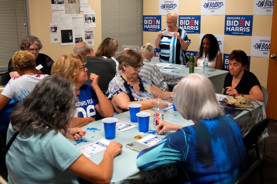 DeAnna Mireau, top, calls out the subjects during a game of bingo at a campaign event for seniors in support of President Joe Biden's reelection campaign, Thursday, June 13, 2024, in Phoenix. (AP Photo/Rick Scuteri)