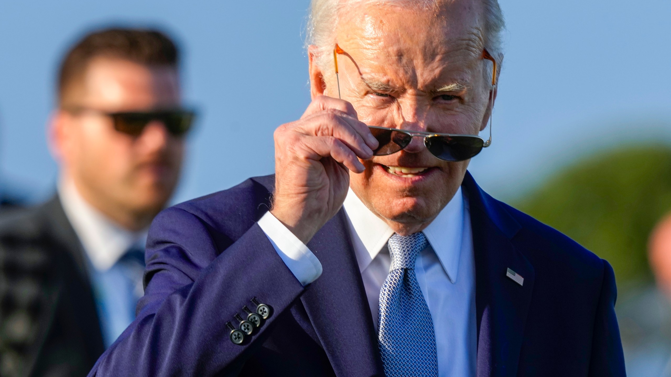 U.S. President Joe Biden puts on his sun glasses after watching a skydiving demo during the G7 world leaders summit at Borgo Egnazia, Italy, Thursday, June 13, 2024. (AP Photo/Luca Bruno)