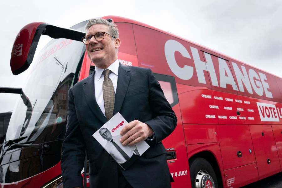 Labour Party leader Sir Keir Starmer arrives on board his election battle bus at a campaign event in Halesowen county of West Midlands, England, Thursday, June 13, 2024, after unveiling Labour's manifesto in Manchester for the forthcoming General Election on July 4. (Stefan Rousseau/PA via AP)