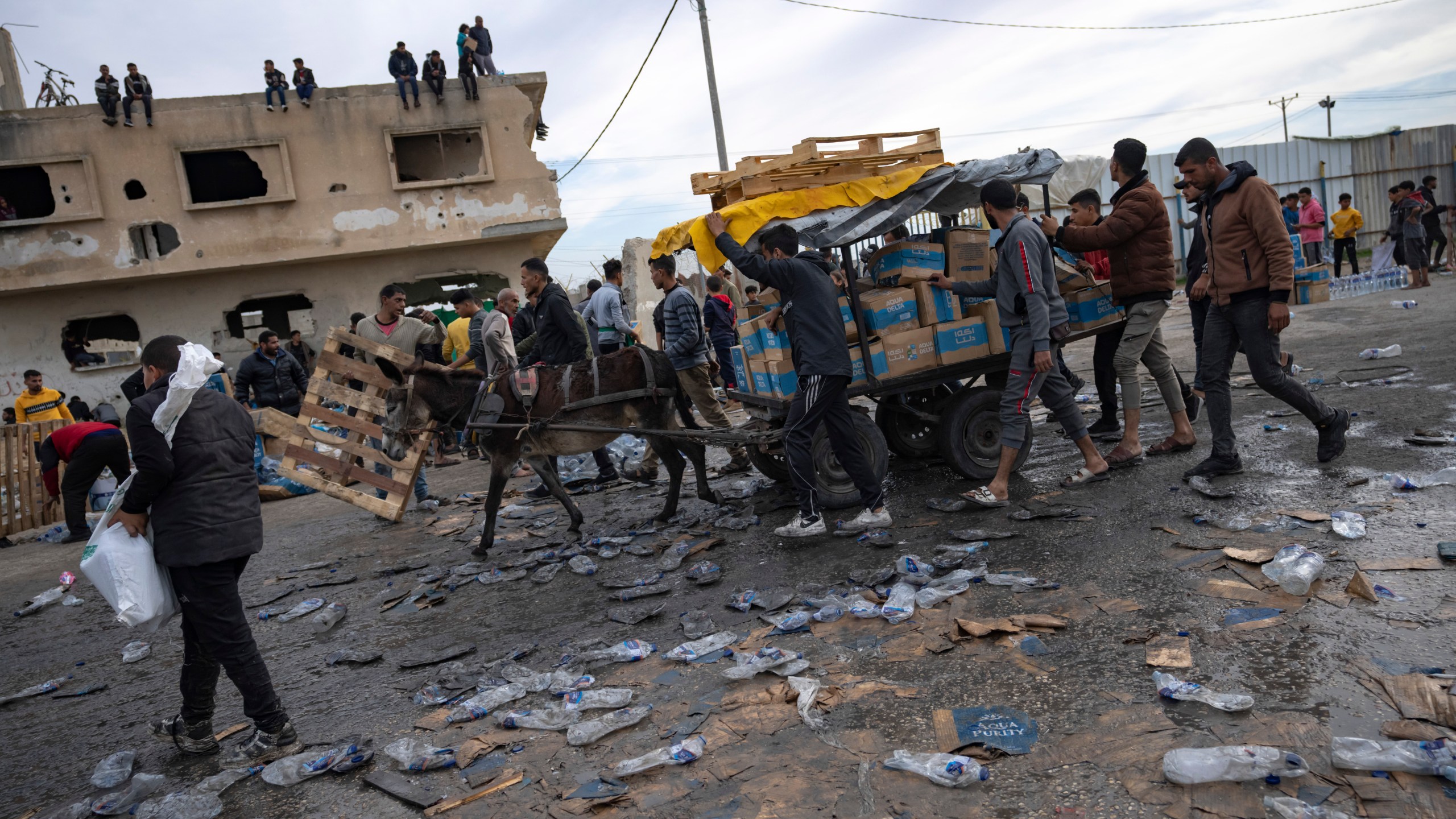 FILE - Palestinians loot a humanitarian aid truck as it crossed into the Gaza Strip in Rafah, Sunday, Dec. 17, 2023. A persistent breakdown in law and order is rendering an aid route in south Gaza unusable, the UN and NGOs say, days after Israel's military said it would pause combat there to help aid reach desperate Palestinians. (AP Photo/Fatima Shbair, File)