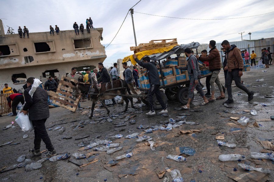 FILE - Palestinians loot a humanitarian aid truck as it crossed into the Gaza Strip in Rafah, Sunday, Dec. 17, 2023. A persistent breakdown in law and order is rendering an aid route in south Gaza unusable, the UN and NGOs say, days after Israel's military said it would pause combat there to help aid reach desperate Palestinians. (AP Photo/Fatima Shbair, File)