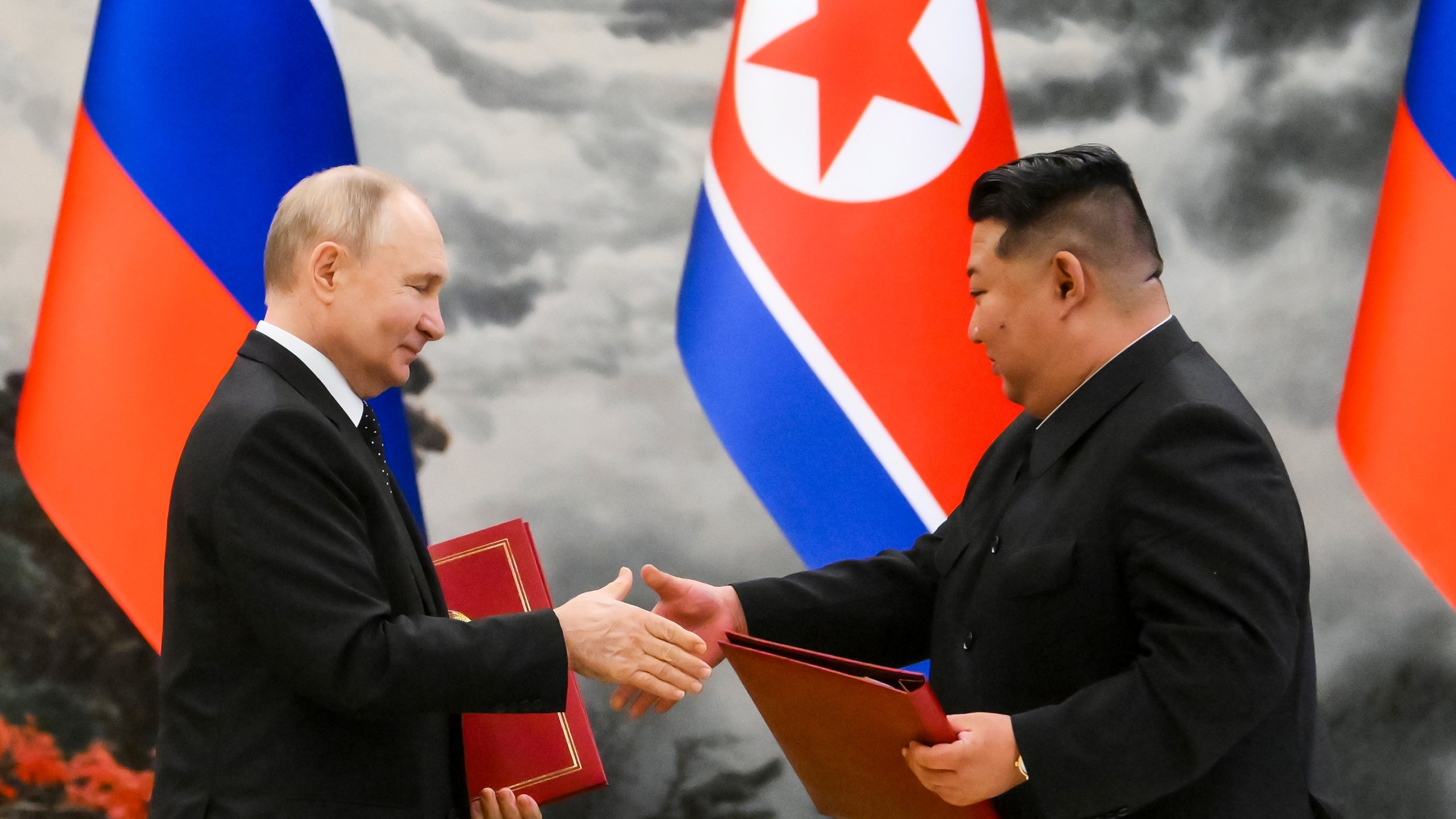 Russian President Vladimir Putin, left, and North Korea's leader Kim Jong Un exchange documents during a signing ceremony of the new partnership in Pyongyang, North Korea, on Wednesday, June 19, 2024. Putin and Kim signed a new partnership that includes a vow of mutual aid if either country is attacked, during a Wednesday summit that came as both face escalating standoffs with the West. (Kristina Kormilitsyna, Sputnik, Kremlin Pool Photo via AP)