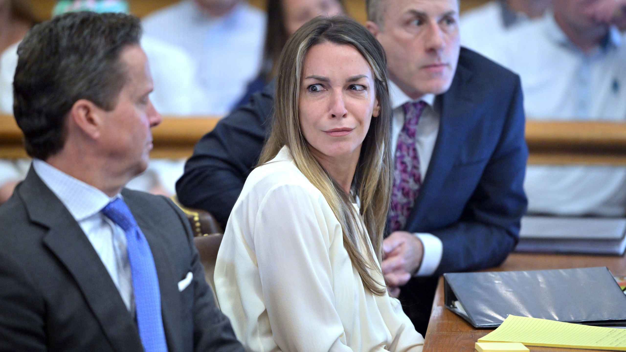 Karen Read, center, reacts to testimony from Dr. Irini Scordi-Bello, a medical examiner for the state's medical examiner's office during Read's trial in Norfolk Superior Court, Friday, June 21, 2024, in Dedham, Mass. Read, 44, is accused of running into her Boston police officer boyfriend with her SUV in the middle of a nor'easter and leaving him for dead after a night of heavy drinking. (AP Photo/Josh Reynolds, Pool)