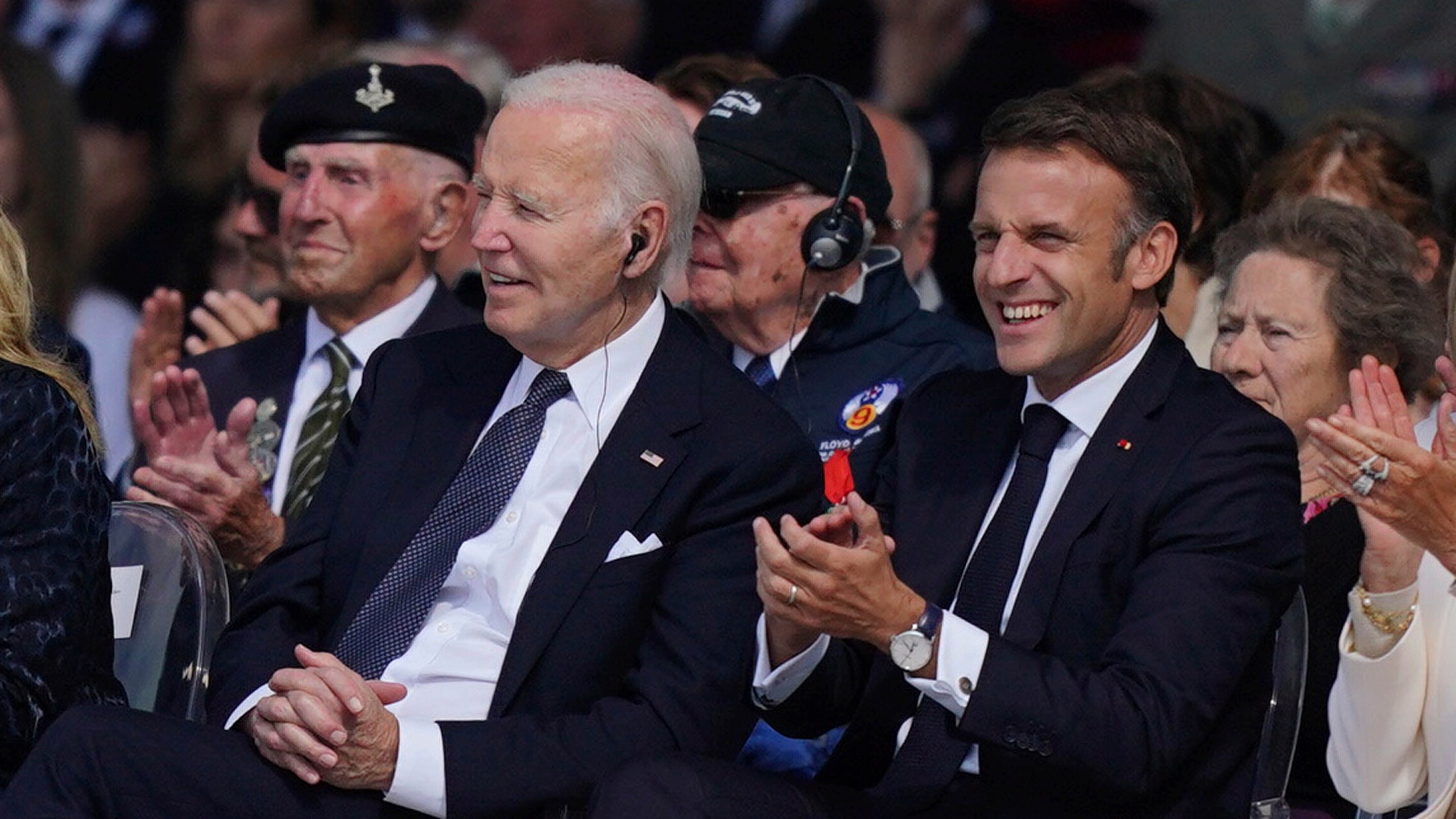 FILE - President Joe Biden, left, and President of France Emmanuel Macron attend the official international ceremony to mark the 80th anniversary of D-Day, at Omaha Beach in Saint-Laurent-sur-Mer, Normandy, France, June 6, 2024. Biden's simple act of sitting down at the D-Day event gained attention as social media users shared a shortened version of the clip to falsely claim he was reaching for a nonexistent chair. Republicans have shared a spate of misleading, out-of-context videos to fuel a narrative that President Joe Biden is mentally and physically unfit for office. These widespread misleading videos show how the reach of social media and real concerns about Biden's age have made the tactic especially powerful in 2024. (Jordan Pettitt/Pool Photo via AP, File)