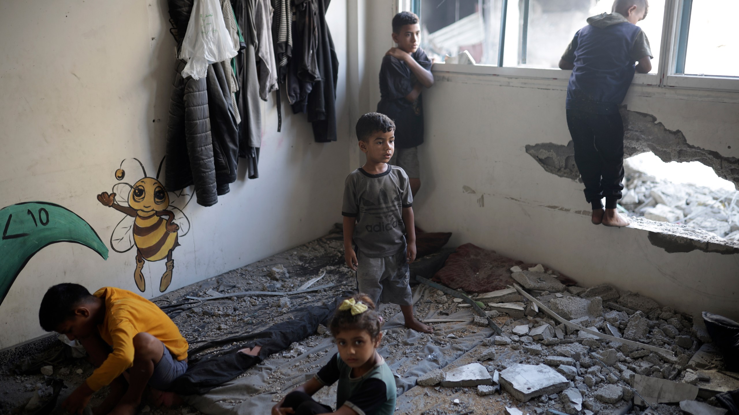 Palestinian children inspect heavy damage to a UNRWA school sheltering displaced persons the day after a nearby house was targeted by Israeli bombardment in Khan Younis, southern Gaza Strip, Friday, June 21, 2024. (AP Photo /Jehad Alshrafi)