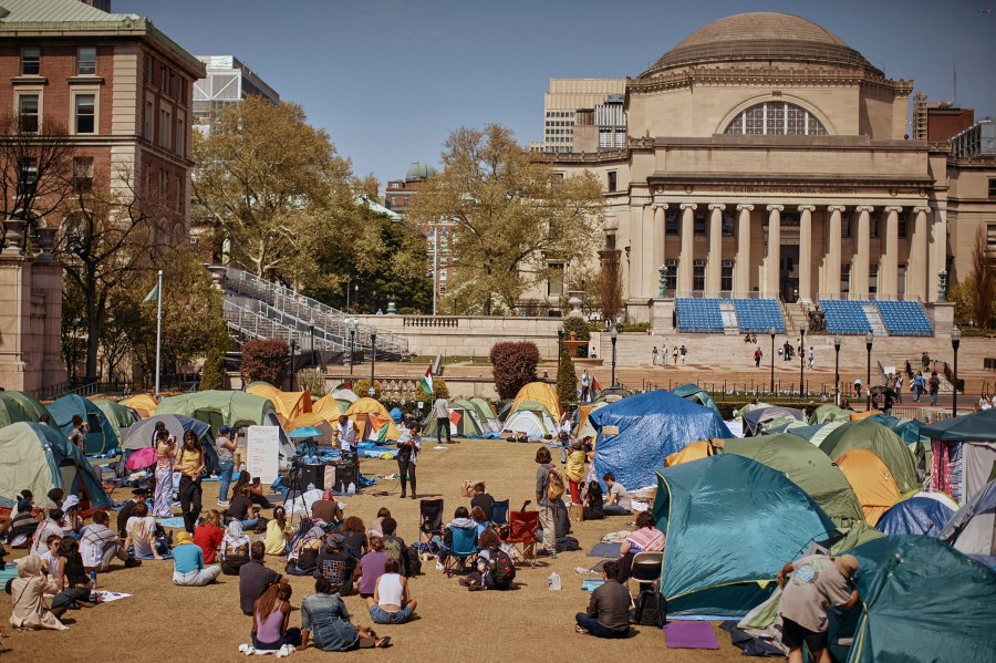 People listen to a speaker at a pro-Palestinian encampment at Columbia University calling for a permanent cease-fire in Gaza.