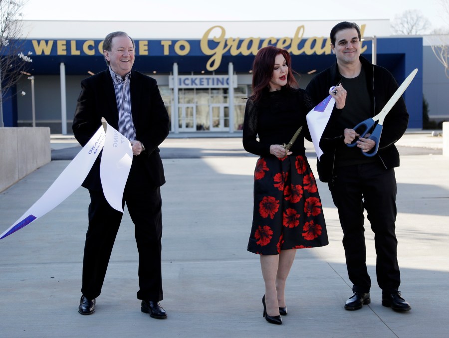 FILE - Priscilla Presley, center stands next to Jack Soden, left, Elvis Presley Enterprises president, and Joel Weinshanker, Graceland Holdings managing partner, during the grand opening of the "Elvis Presley's Memphis" complex, March 2, 2017, in Memphis, Tenn. The Memphis Music Hall of Fame inducted its inaugural class of 25 luminaries at a rousing ceremony 12 years ago, honoring legends spanning generations and genres, from Elvis Presley to ZZ Top to Three 6 Mafia. (AP Photo/Mark Humphrey, File)