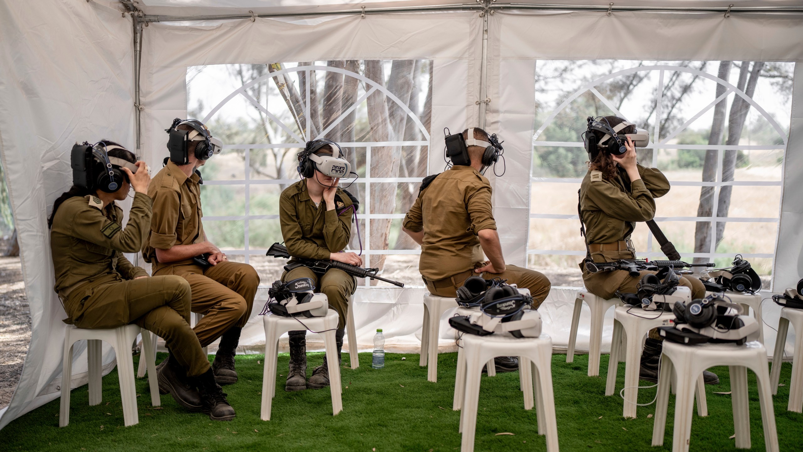 Israeli soldiers watch a virtual tour of the destruction of the aftermath of the Oct. 7 Hamas attack on Israel near the site of the Tribe of Nova music festival, where at least 364 people were killed and abducted near Kibbutz Re'im, southern Israel, Thursday, May 30, 2024. A new kind of tourism has emerged in Israel in the months since Hamas’ Oct. 7 attack. For celebrities, politicians, influencers and others, no trip is complete without a somber visit to the devastated south that absorbed the brunt of the assault near the border with Gaza. (AP Photo/Oded Balilty)