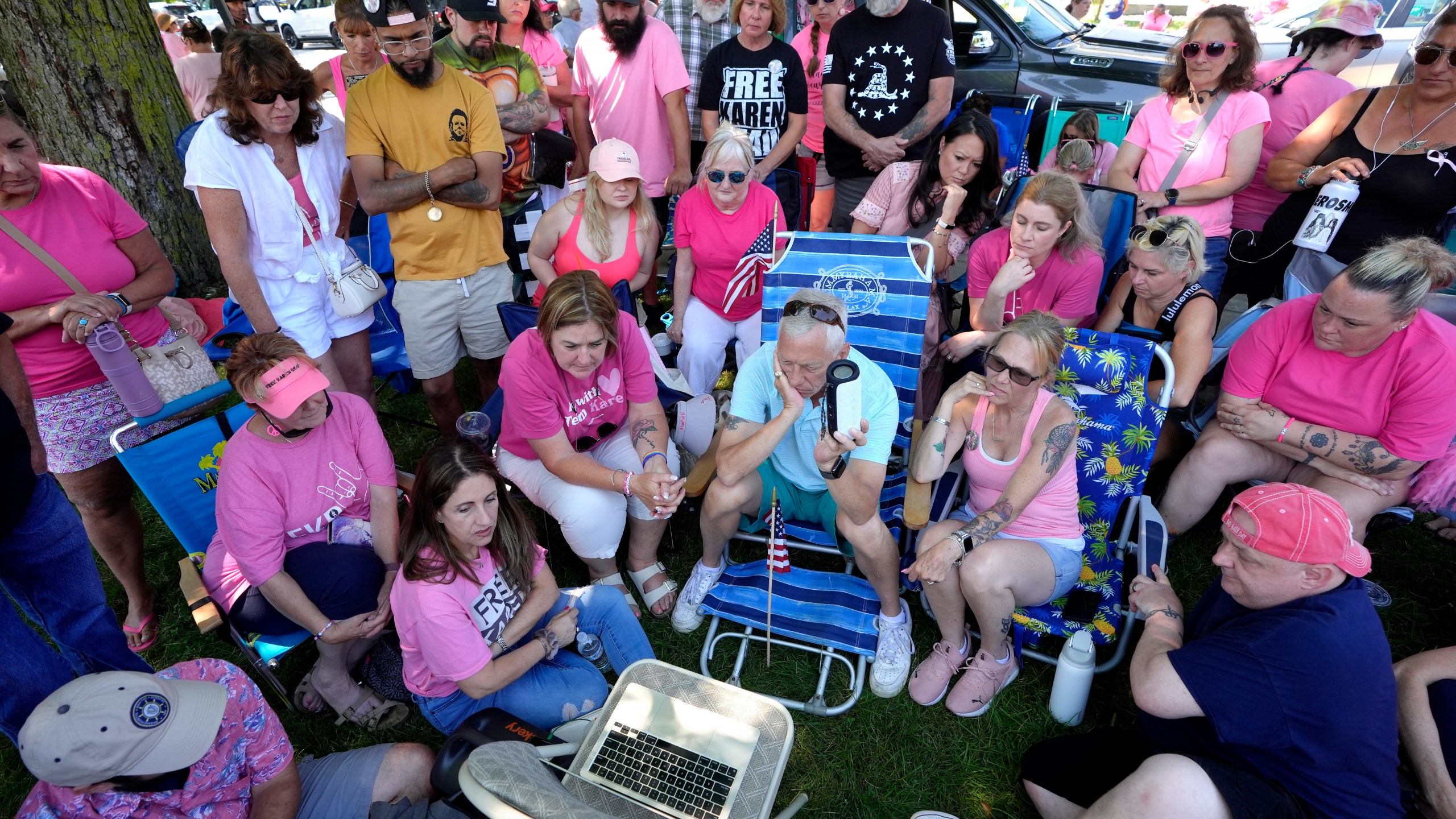 Supporters of Karen Read listen to proceedings from Read's trial from a laptop computer while gathered a block away from Norfolk Superior Court, Tuesday, June 25, 2024, in Dedham, Mass. Karen Read is on trial accused of killing her boyfriend Boston police Officer John O'Keefe, in 2022. (AP Photo/Steven Senne)