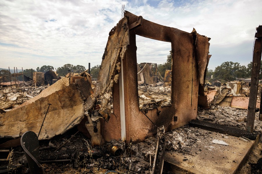 The remains of a structure destroyed by the Apache Fire as it burns in Palermo, Calif., on Tuesday, Jun. 25, 2024. According to Cal Fire, more than a dozen new fires sparked by lightning. (AP Photo/Ethan Swope)