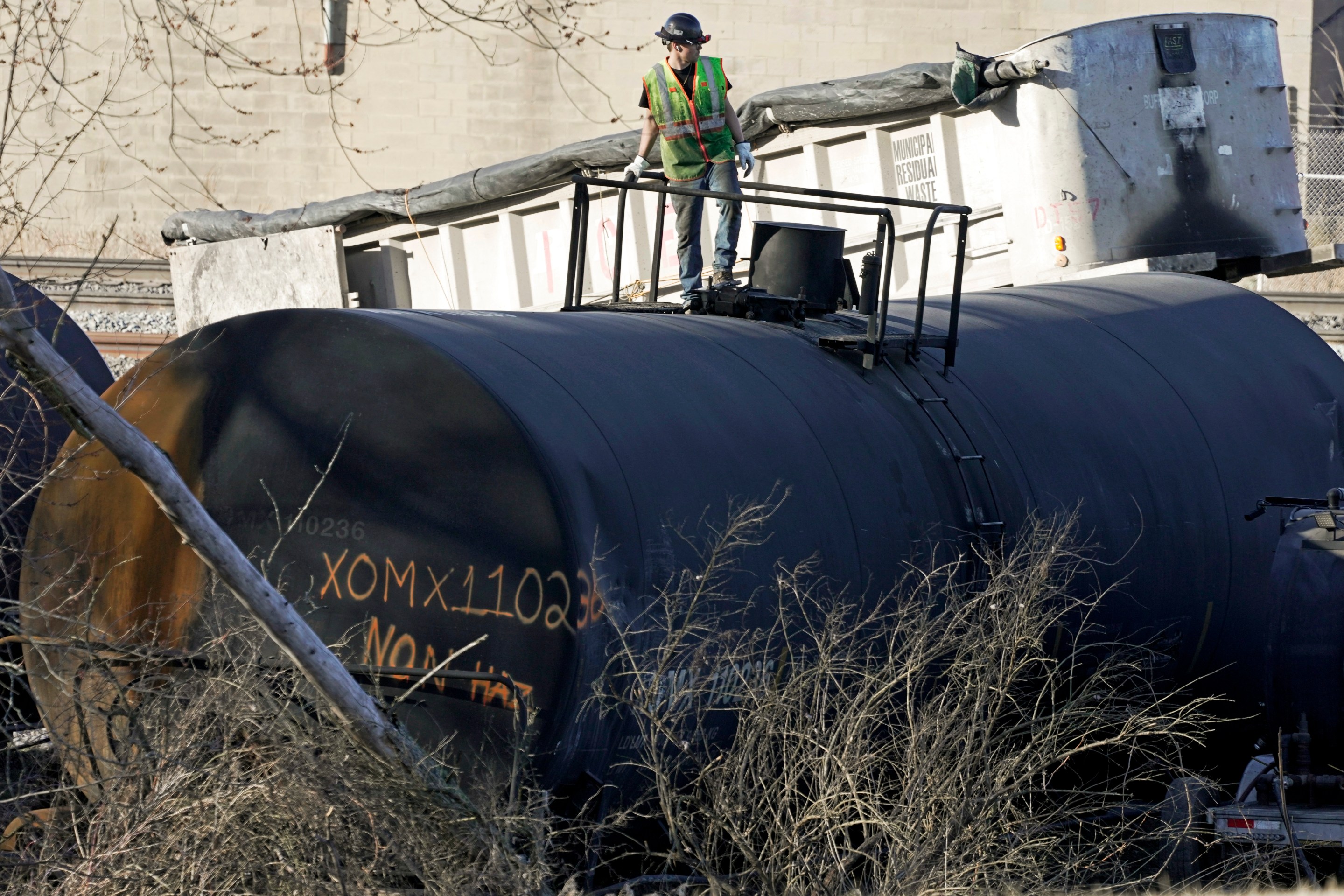 FILE - A cleanup worker stands on a derailed tank car of a Norfolk Southern freight train in East Palestine, Ohio, continues, Feb. 15, 2023. The National Transportation Safety Board’s daylong hearing on what caused the East Palestine derailment and how to prevent similar disasters gave the community, railroads and policymakers plenty to think about. (AP Photo/Gene J. Puskar, File)