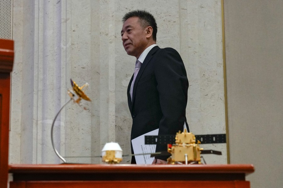 Bian Zhigang, Deputy Director of the China National Space Administration walks by Chang'e 6 probe models as he arrives for a press conference at the State Council Information Office in Beijing, Thursday, June 27, 2024. China's space officials said Thursday they welcomed scientists from across the world to apply to study the lunar rock samples the Chang'e 6 probe brought back to earth in a historic mission, but noted there were limits to that cooperation, specifically with the U.S. (AP Photo/Andy Wong)