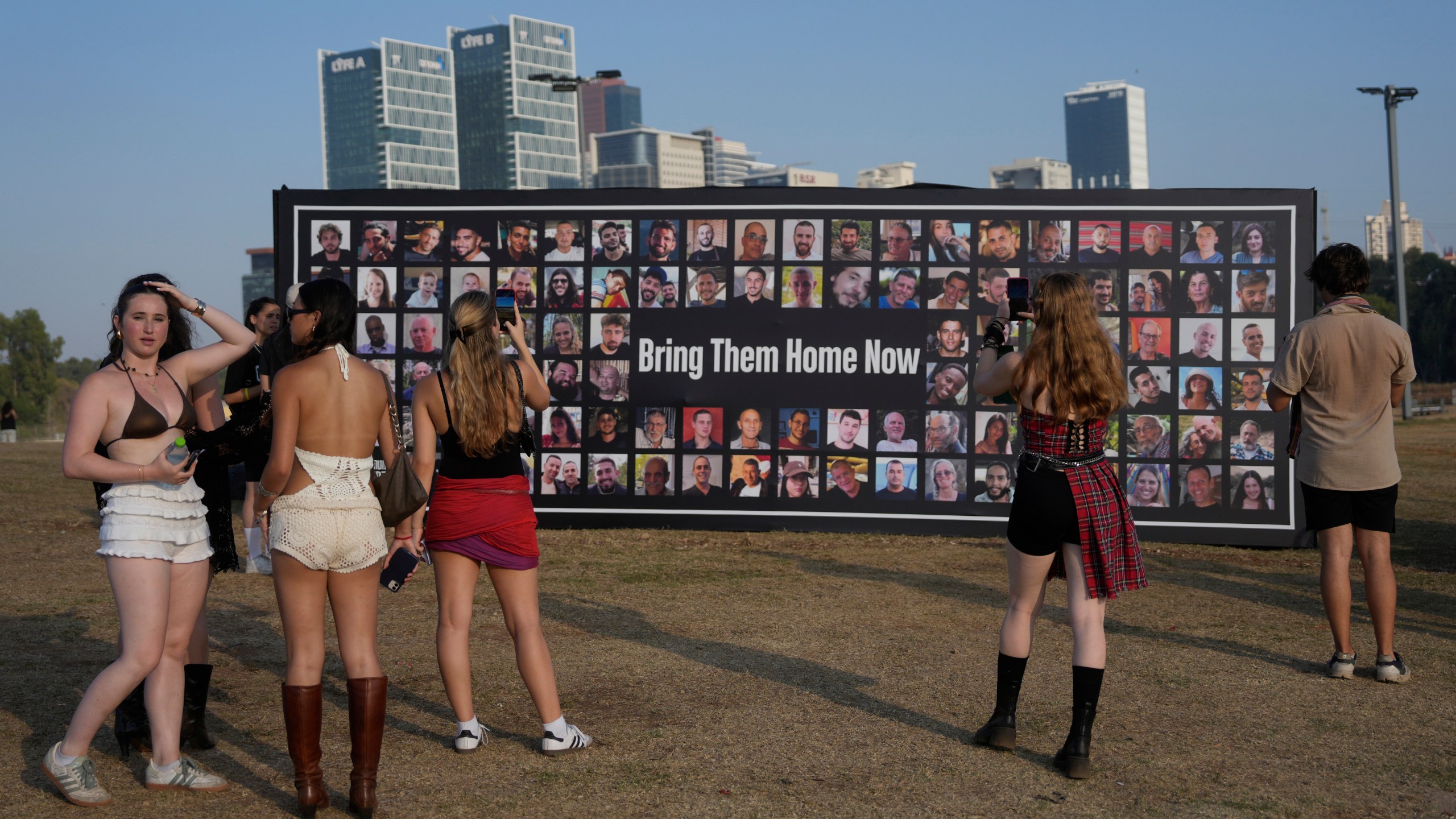 People pause at a picture display of hostages held in the Gaza Strip at the Nova Healing Concert in Tel Aviv, Israel, on Thursday, June 27, 2024