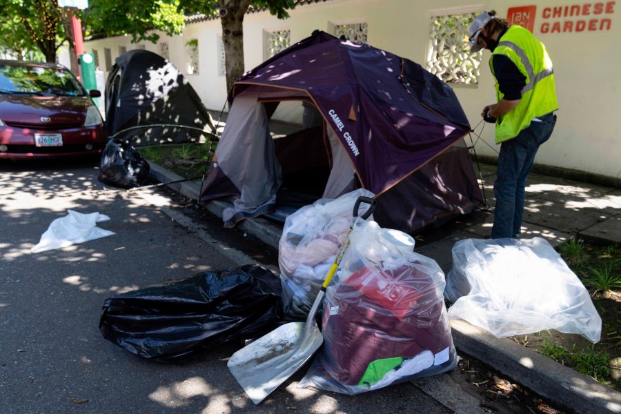 A picture of a tent being dismantled after the person who resided there was detained.