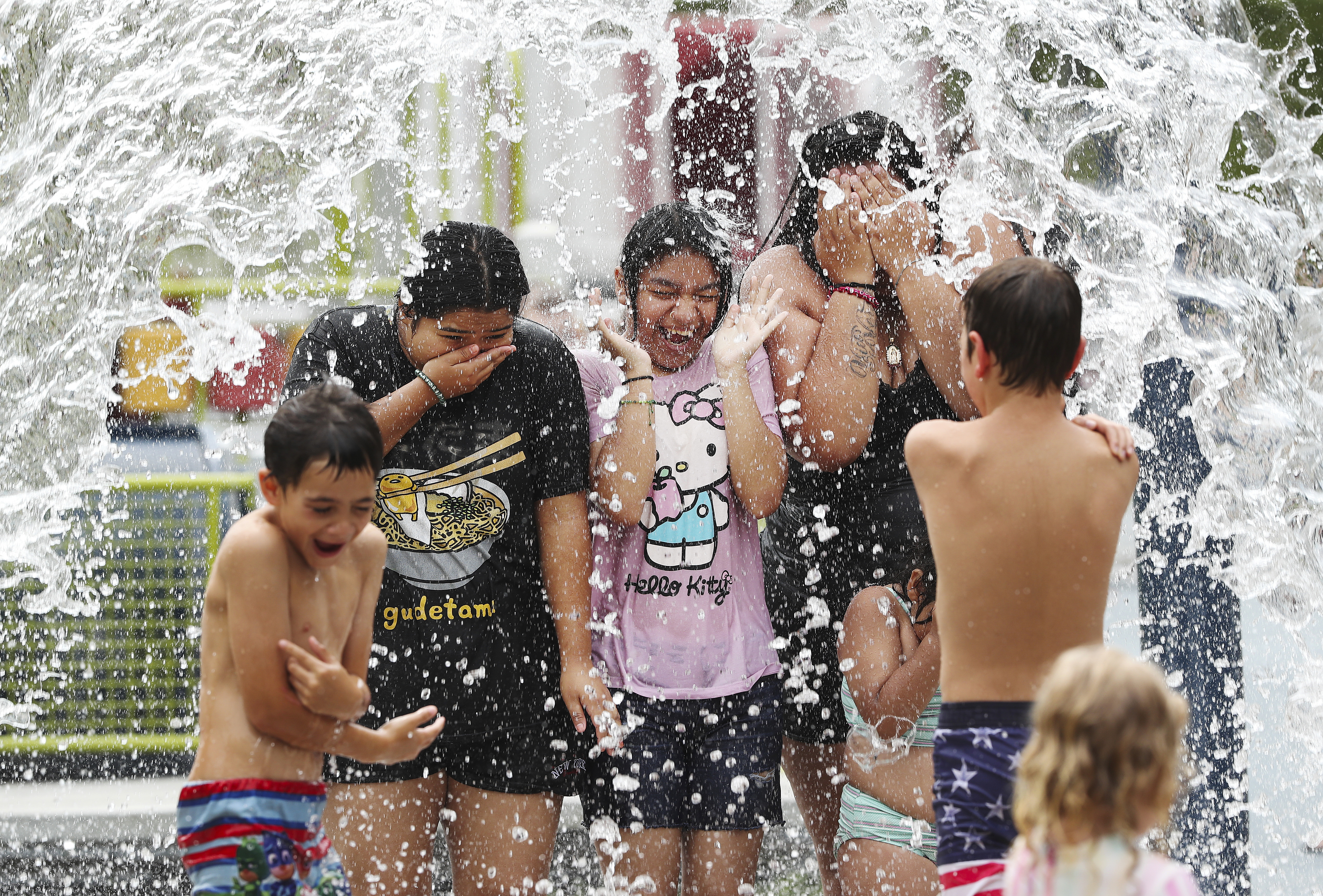 Children play in a splash pad in Louisville, Ky., on Tuesday, June 18, 2024.