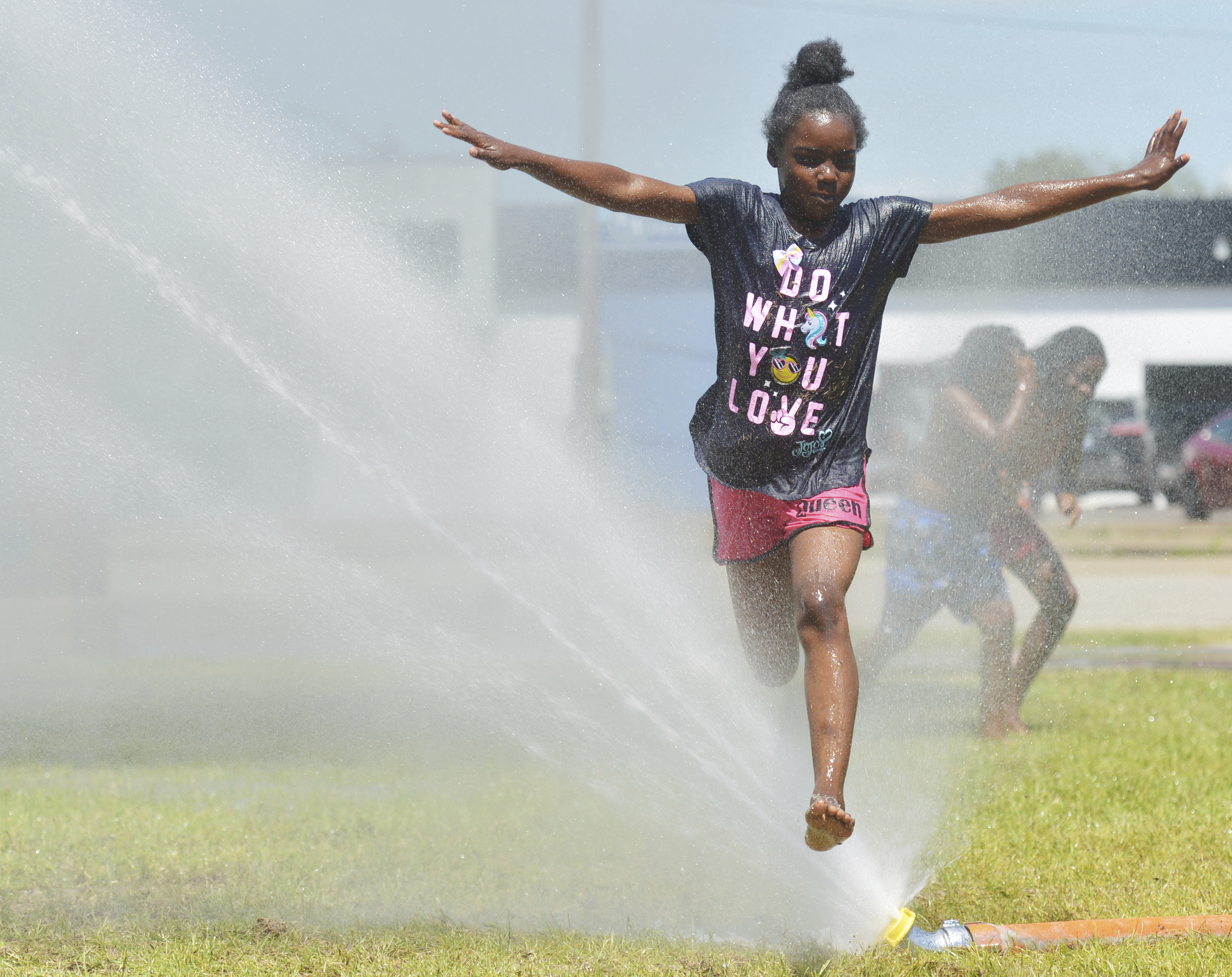 A girl plays in water provided by the fire department June 18,2024.