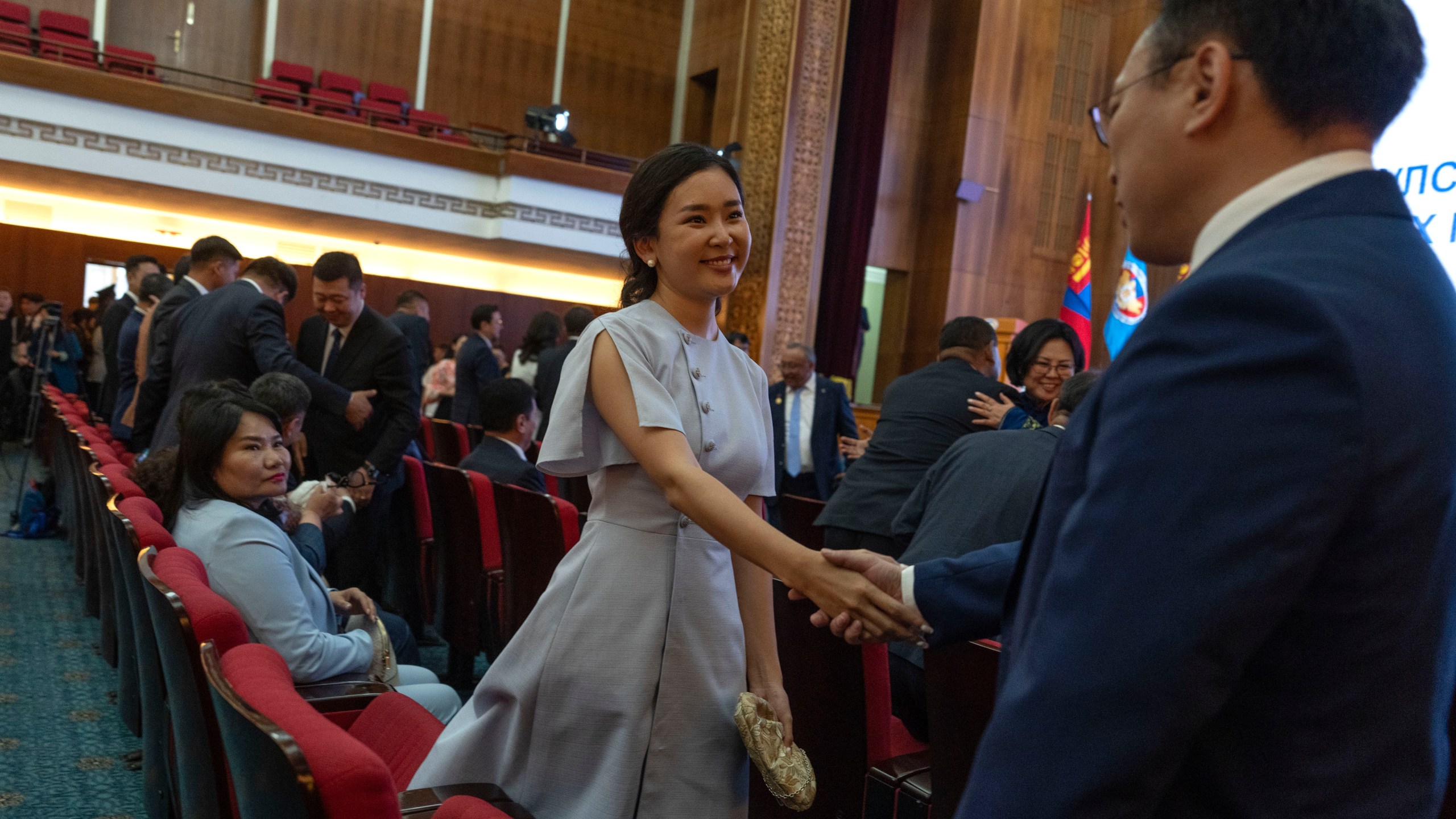 Tsenguun Saruulsaikhan, a young and newly minted member of Mongolia's parliament, shakes hands with colleagues before receiving her Parliament membership card at a ceremony held at the Government Palace in Ulaanbaatar, Mongolia, Monday, July 1, 2024. Tsenguun was one of 42 winning candidates from the Democratic Party, the main opposition group, which made a major comeback after being reduced to a handful of seats in the 2016 and 2020 elections. (AP Photo/Ng Han Guan)