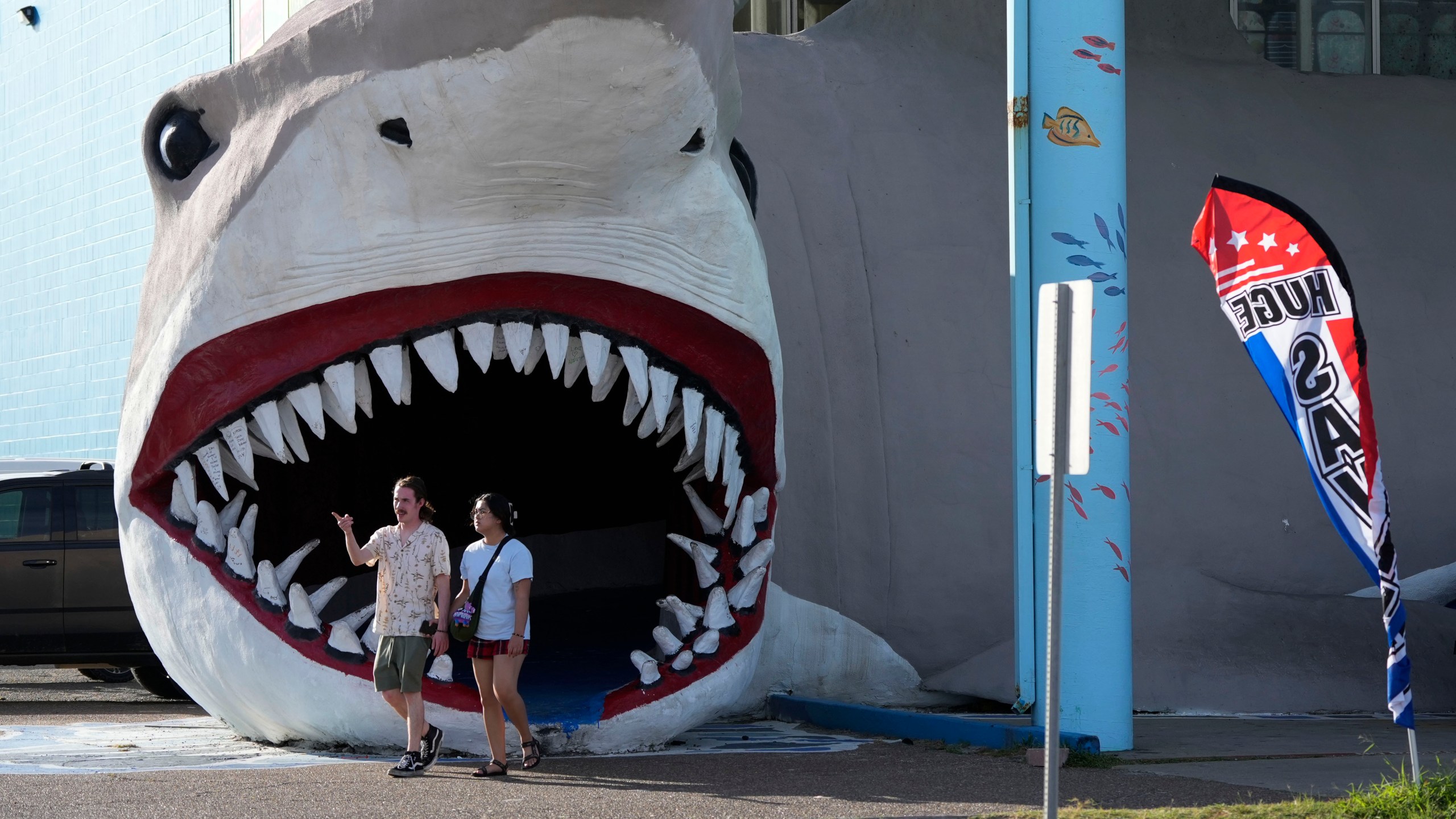 Shoppers exit a souvenir shop as Beryl advances towards the Texas coast, Saturday, July 6, 2024, in Port Aransas, Texas. (AP Photo/Eric Gay)