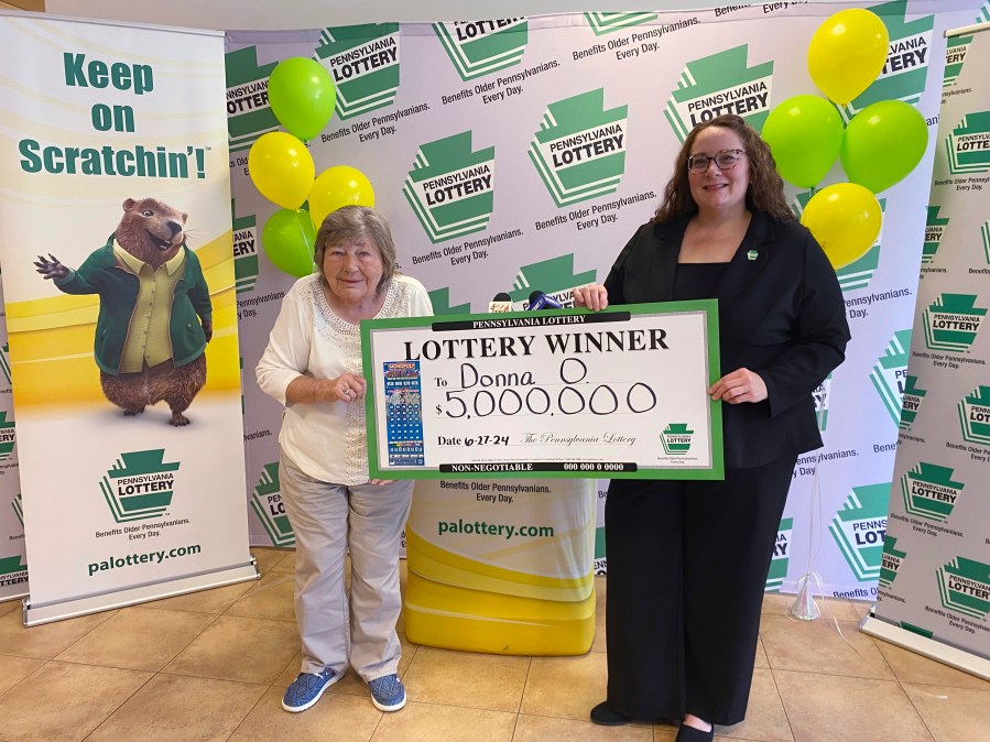 This image provided by the Pennsylvania Lottery shows Donna Osborne, 75, left, posing for a photo with PA Lottery Deputy Director of Corporate Sales Staci Coombs at Lottery Headquarters in Middletown, Pa. (Pennsylvania Lottery via AP)