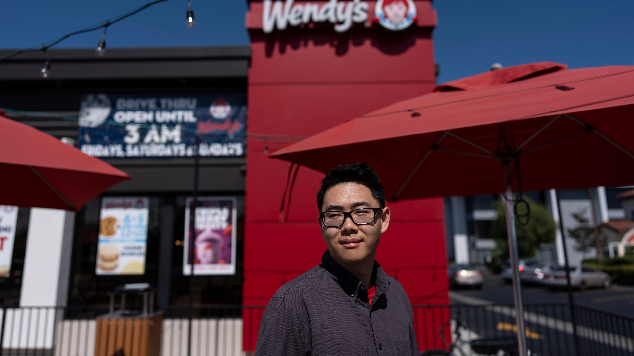 Lawrence Cheng, whose family owns seven Wendy's locations south of Los Angeles, stands for a photo outside his Wendy's restaurant in Fountain Valley, Calif., June 20, 2024. Cheng used to have nearly a dozen employees at the location during the day. Now, he only schedules seven for each shift as he scrambles to absorb a dramatic jump in labor costs after a new California law boosted the hourly wage for fast food workers on April 1 from $16 to $20 an hour. (AP Photo/Jae C. Hong)