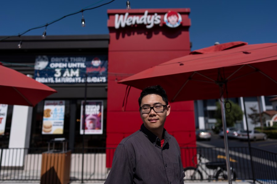 Lawrence Cheng, whose family owns seven Wendy's locations south of Los Angeles, stands for a photo outside his Wendy's restaurant in Fountain Valley, Calif., June 20, 2024. Cheng used to have nearly a dozen employees at the location during the day. Now, he only schedules seven for each shift as he scrambles to absorb a dramatic jump in labor costs after a new California law boosted the hourly wage for fast food workers on April 1 from $16 to $20 an hour. (AP Photo/Jae C. Hong)