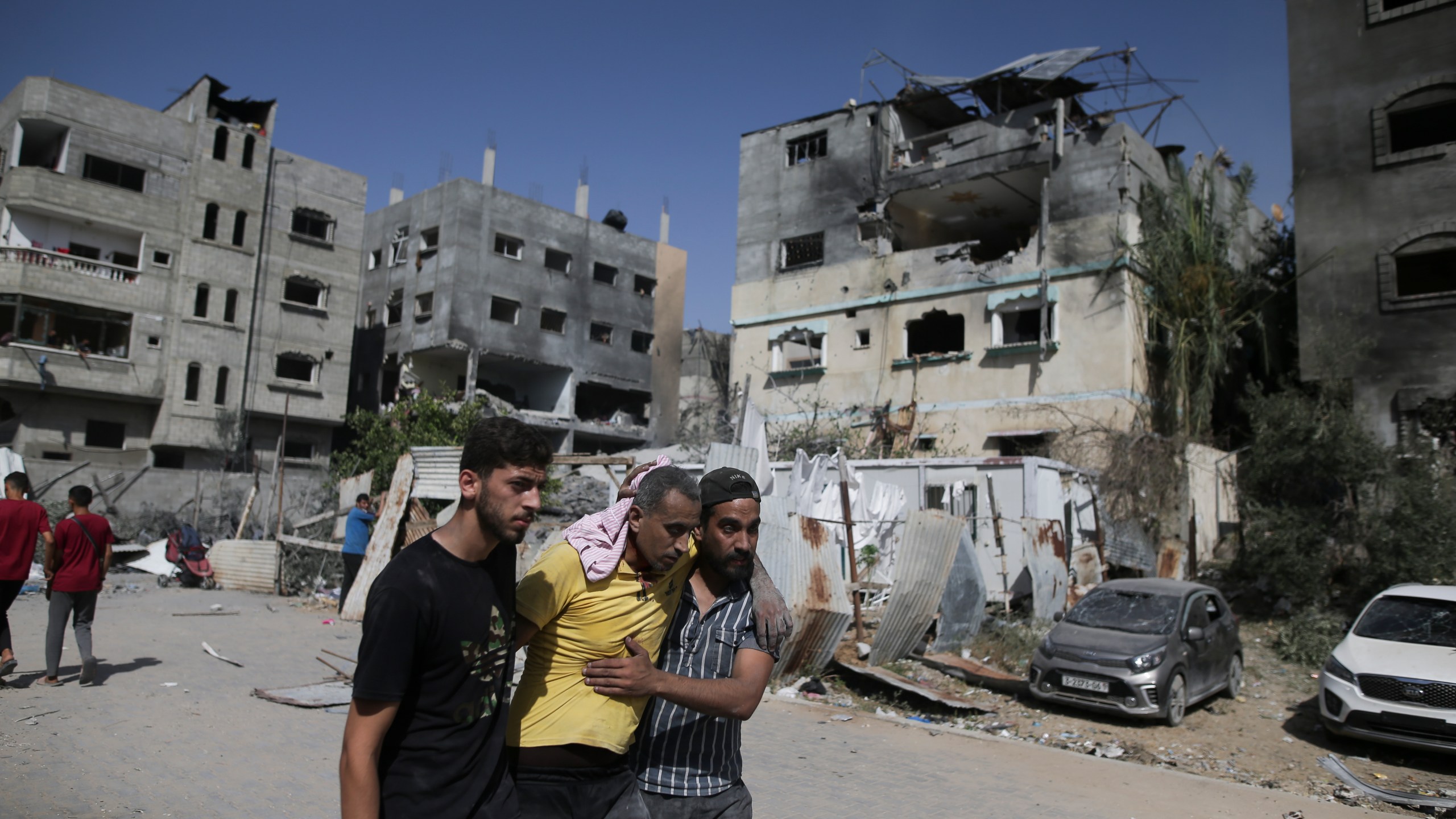 FILE - Palestinians help a wounded man after Israeli strikes in Nuseirat refugee camp, Gaza Strip, on June 8, 2024. The United Nations chief appealed for funding Friday, July 12, 2024, for the beleaguered U.N. agency helping Palestinian refugees in Gaza and elsewhere in the Middle East, accusing Israel of issuing evacuation orders in the war-torn territory forcing Palestinians “to move like human pinballs across a landscape of destruction and death.”(AP Photo/Jehad Alshrafi, File)