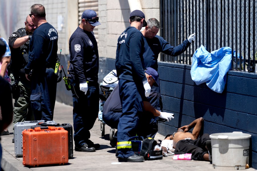 FILE - Phoenix firefighters give medical attention to a homeless man in the heat, May 30, 2024, in Phoenix. Heat is the top cause of weather-related fatalities nationwide. But because investigations of suspected heat deaths can take months, and mishmash of methods counties use to count them, we really don't know exactly how many people died in the most recent heat wave stretching back to July 1 (AP Photo/Matt York, File)